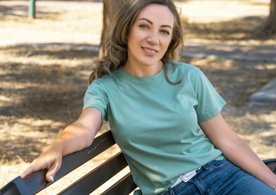 Smiling Middle-aged women sits on the bench outdoor